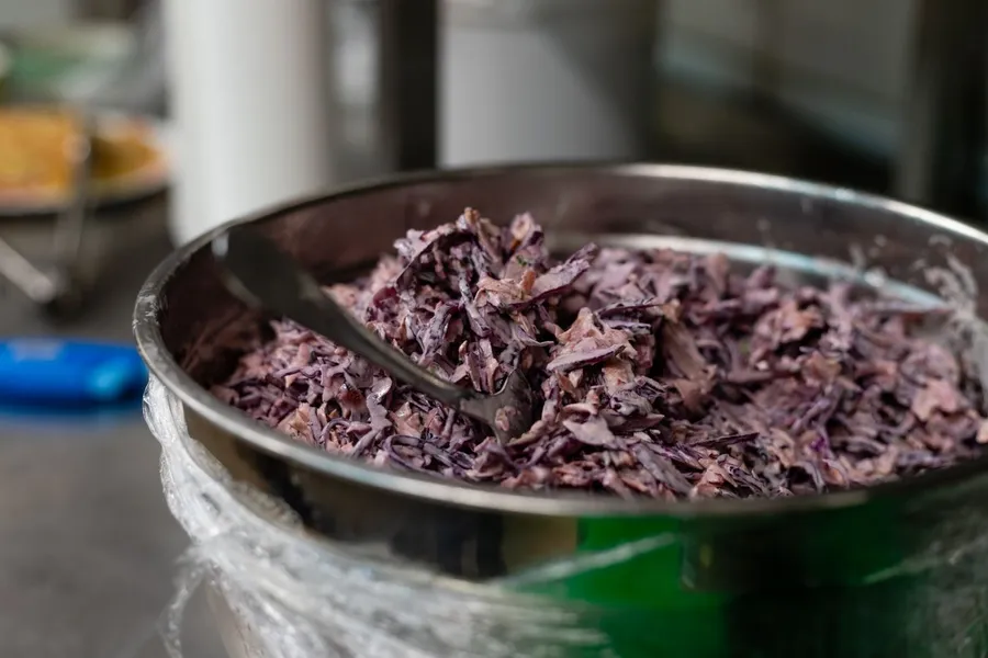 Fresh coleslaw in a metal bowl with cabbage and vegetables