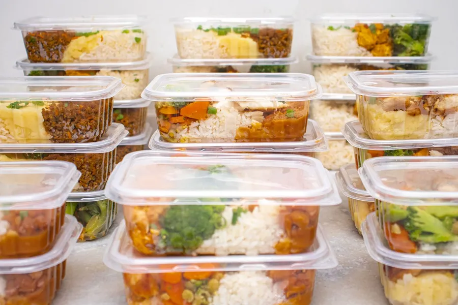 Stacked meal prep containers with rice and vegetables