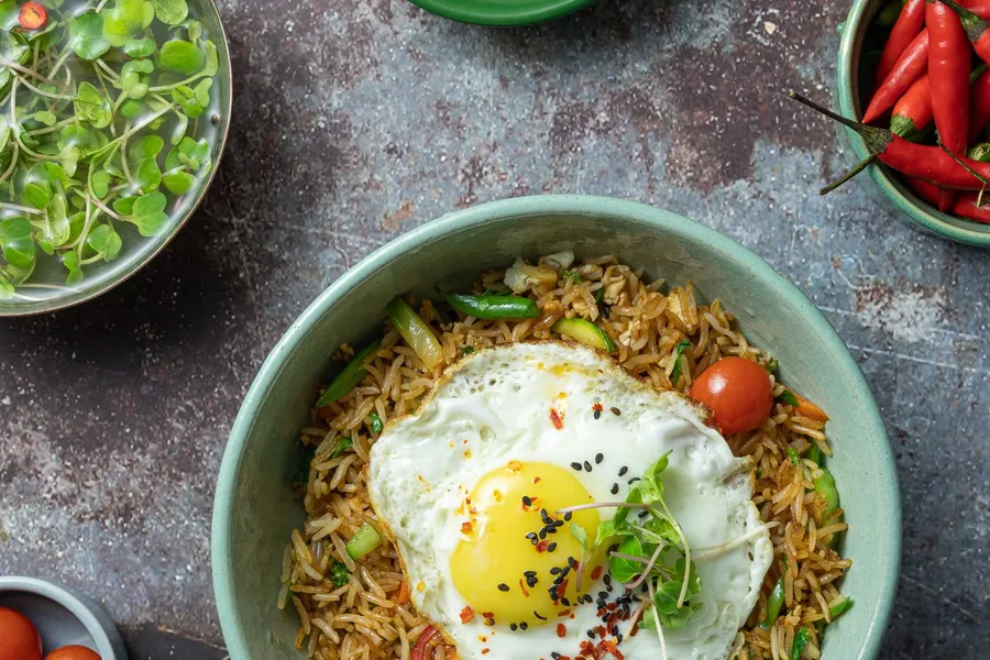 Bowl of fried rice with vegetables and a fried egg on top